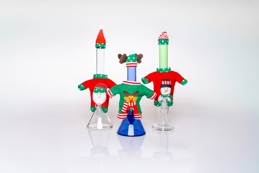 Set of three glass Christmas-themed vases on a white background