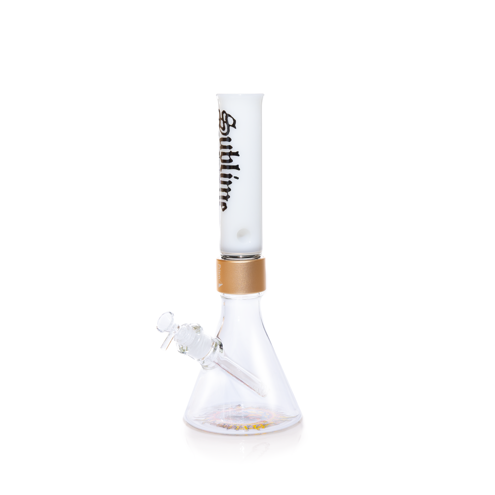 Official Prism x Sublime collaborative modular water pipe featuring a clear glass beaker base with the iconic yellow sun logo by Opie Ortiz on the bottom. This customizable bong includes a metallic gold Halo Connector and a white glass straight tube mouthpiece adorned with the black Sublime gothic logo and Long Beach, California text.