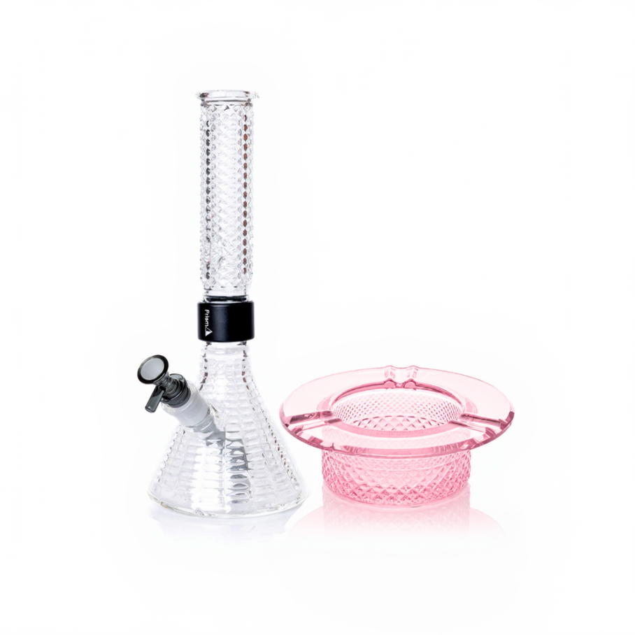 Jane West Ultimate Bundle featuring the clear Prism x Jane West MINI Beaker Bong and matching Twenties Collection Ashtray. The luxury smoking set highlights the diamond-patterned textured glassware and cohesive amber color. The MINI Beaker water pipe is shown with a gold-colored MINI halo connector and 14mm male bowl. Premium glass bundle, designer smoking set, collaborative cannabis glassware, matching amber bong and ashtray, Twenties Collection water pipe.