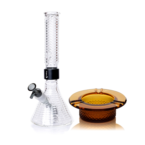 Jane West Ultimate Bundle alternative, pairing the clear Prism x Jane West MINI Beaker Bong with the amber Twenties Collection Ashtray. The clear water pipe features a textured glass base, midnight black downstem and 14mm male bowl, and a black MINI halo connector. The mouthpiece includes one ice pinch for smoother hits. Clear glass beaker bong, black and clear premium water pipe, ice-pinch smoking accessory, Twenties Collection luxury combo, Jane West collaborative glassware.