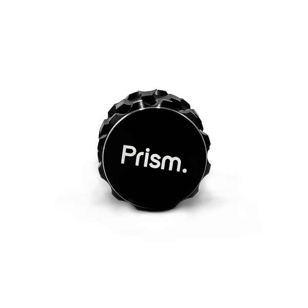 Black 3-Piece aluminum cannabis grinder by Prism Water Pipes. Side view shows branded faceplate and silver, ergonomic grip accents.
